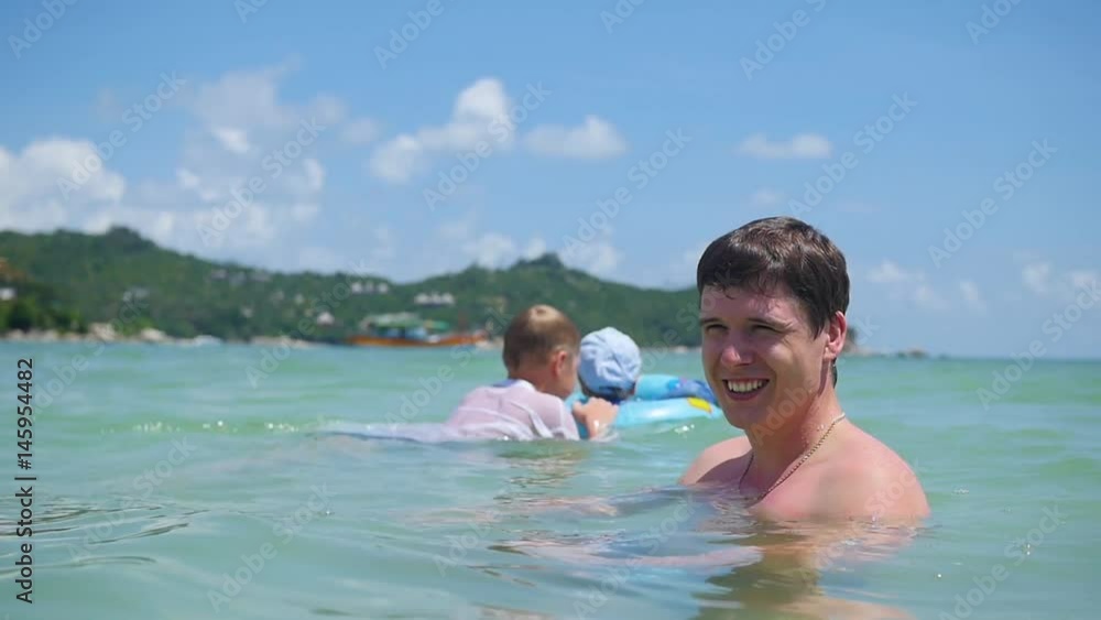 a guy with kids plays having fun in the sea a guy with kids plays having fun in the sea