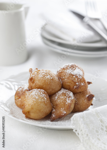 Sweet homemade beignets covered with powdered sugar.