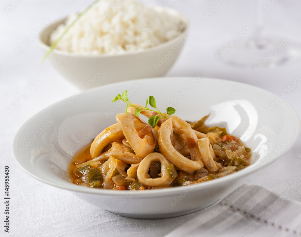 Squid rings cooked in a tasty sauce served with rice. Squid rings cooked in a tasty sauce served with rice.