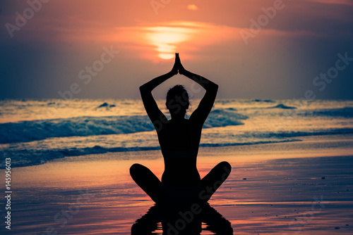 Kobieta ćwicząca jogę przy zachodzie słońca