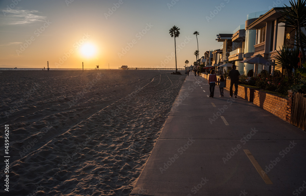 Walking on California's Newport beach pathway at sunset