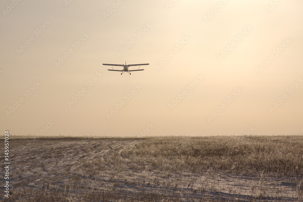 Airplane flying at sunset.