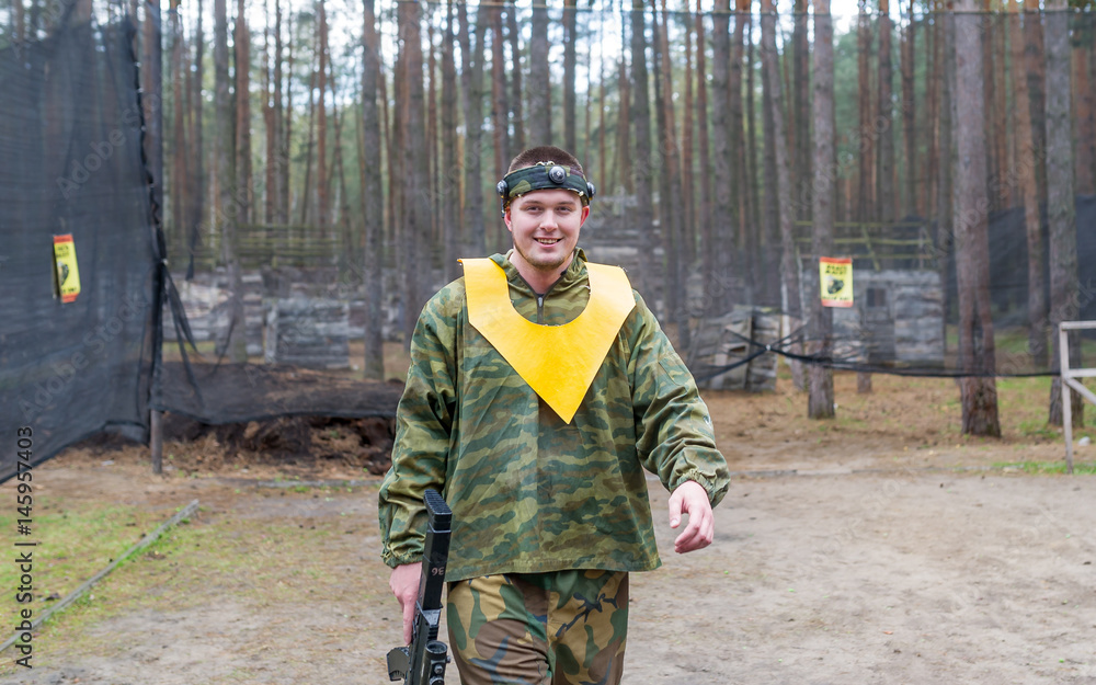 Fototapeta premium Camouflage dressed paintball player walking on the battle ground