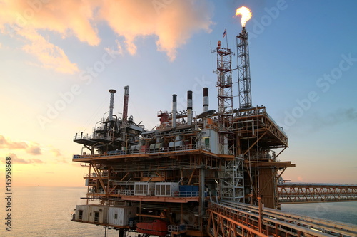 Offshore construction platform for production oil and gas with sunset sky
