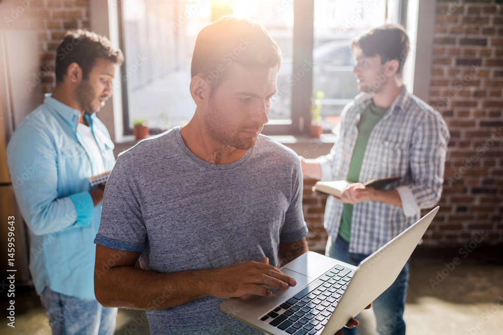 Fototapeta premium young professionals working on new business project with laptop in small business office