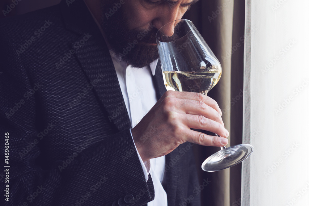 man tasting a glass of white wine man tasting a glass of white wine