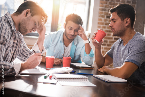 Group of concentrated young professionals working on business project together