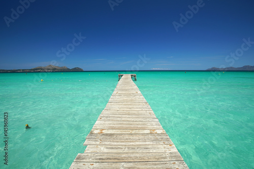 langer Holzsteg am Strand im Sommer