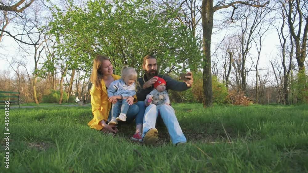 Happy family with two little daughters in the park doing selfie Happy family with two little daughters in the park doing selfie