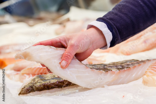 Photography Fishmonger holding a piece of fresh fish in a market