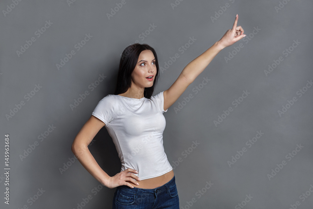 Excited woman shows something, point finger up