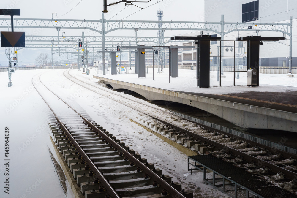 Empty railway and platform covered with snow Empty railway and platform covered with snow