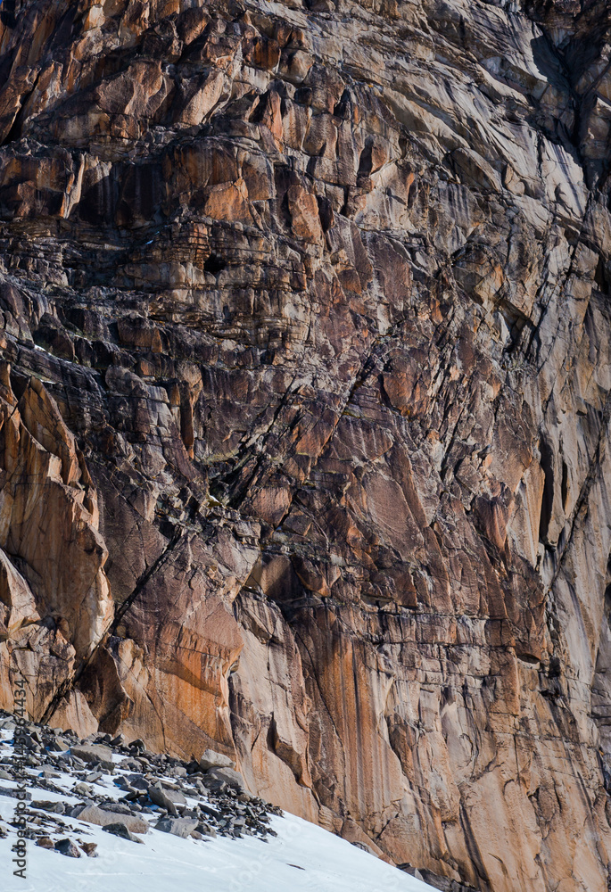 Eroded cracked granite cliff in multiple red iron shades Eroded cracked granite cliff in multiple red iron shades