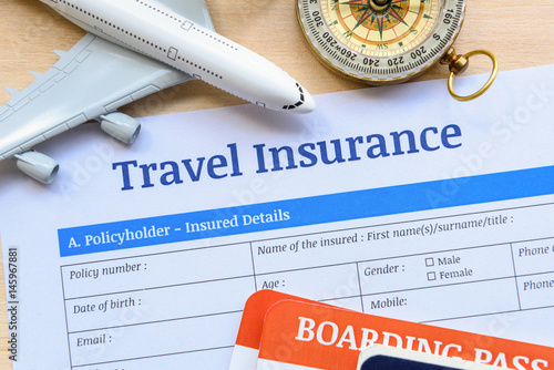 Travel insurance form put on a wood table. Many agent sells airplane tickets or travel packages allow consumers to purchase travel insurance also known as travelers insurance as an added service.