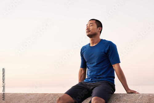 Принти на полотні Athletic Asian man taking a breather during a morning run