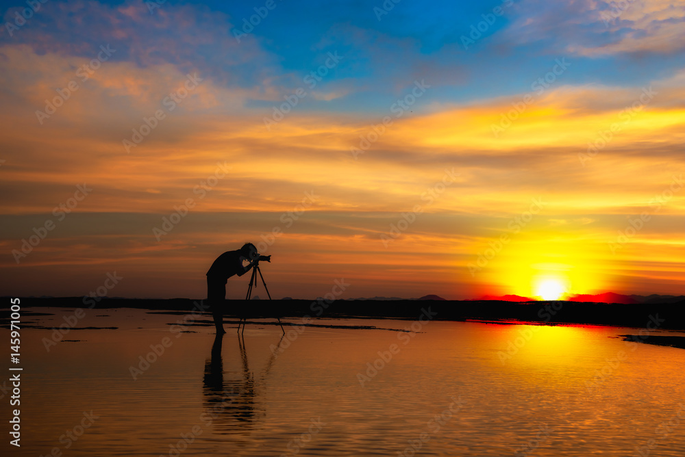 Silhouette Photographer take photo dramatic colorful sunset sky on beach in twilight. Silhouette Photographer take photo dramatic colorful sunset sky on beach in twilight.