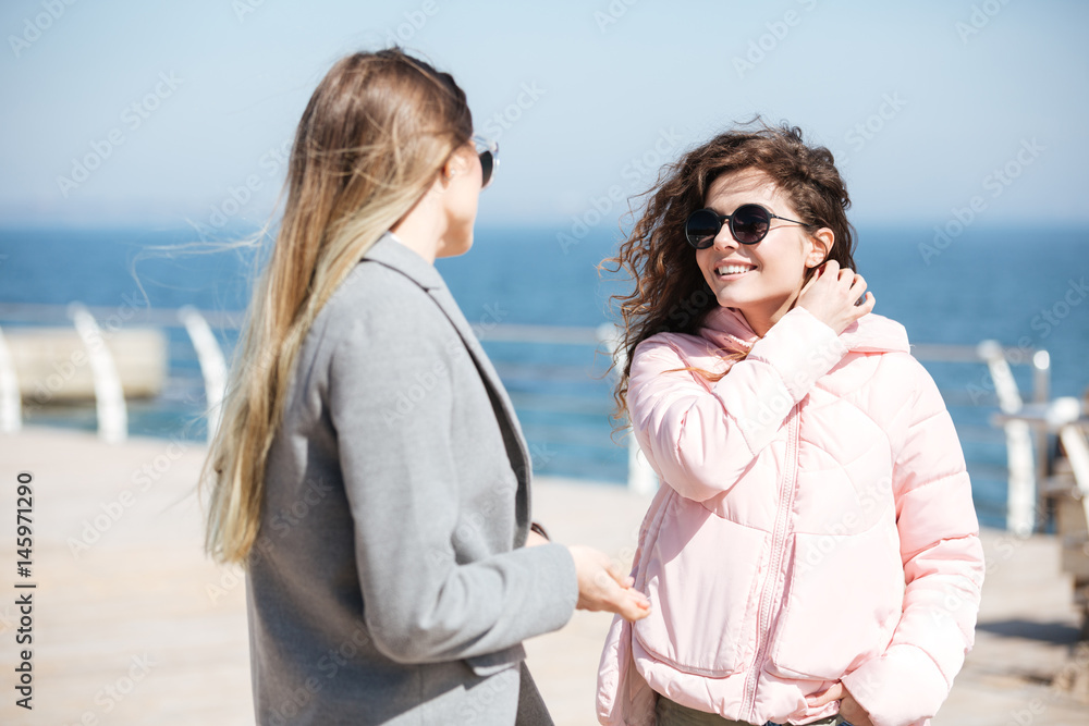 Young women talking near sea