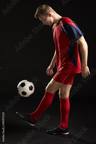 Professional Soccer Player Controlling Ball In Studio