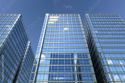 Abstract group of building with bright and clear sky both on background and reflecting on facade. 3D illustration.