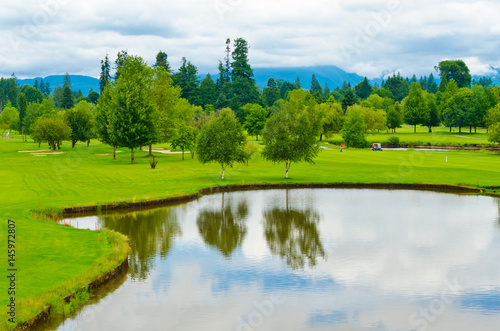 Golf course with gorgeous green and pond.