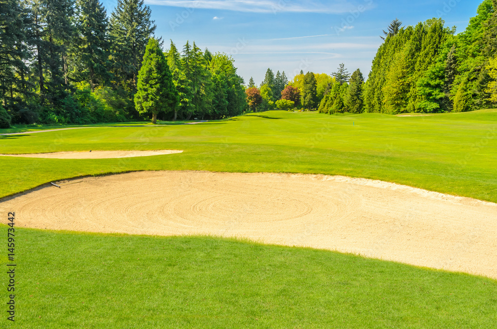 Fototapeta premium Golf course with gorgeous green and sand bunker