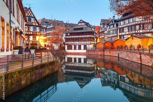 Traditional Alsatian half-timbered houses in Petite France with mirror reflections during morning blue hour, Strasbourg, Alsace, France