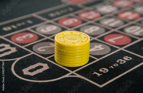 gambling on a roulette table with yellow chips