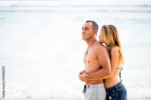 Portrait of happy couple resting together on beach