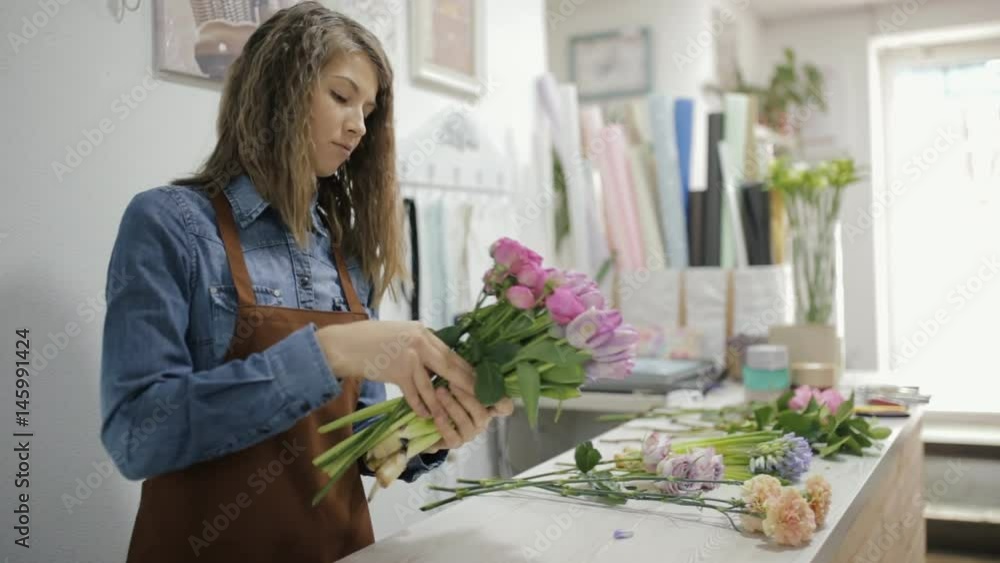 Woman florist make a bouquet of beautiful different flowers Woman florist make a bouquet of beautiful different flowers