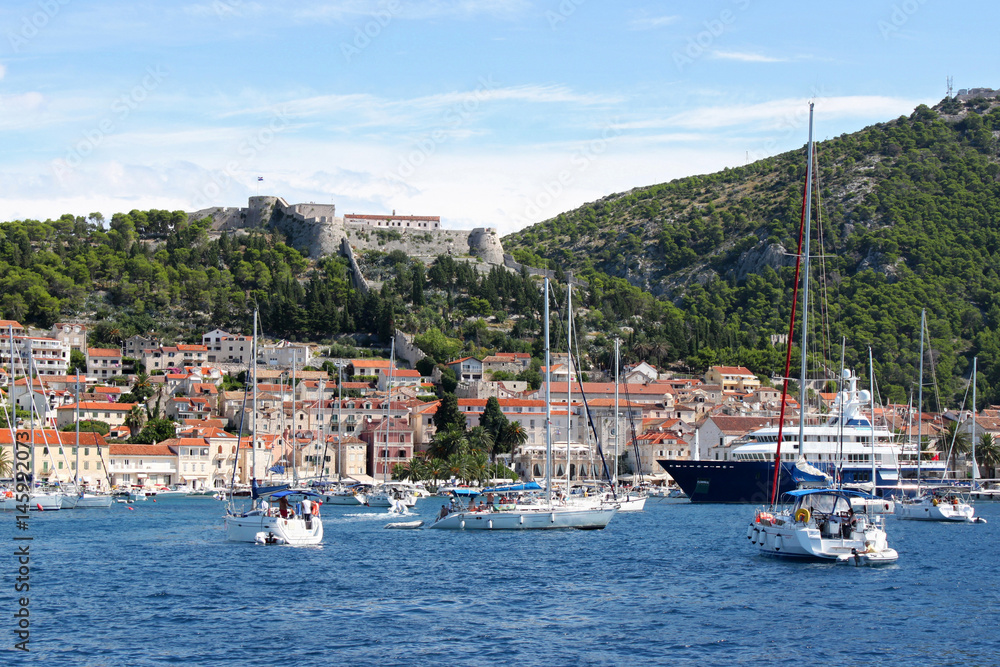 Segelboote und Yachten warten vor dem überfüllten Hafen der Altstadt von Hvar in Kroatien