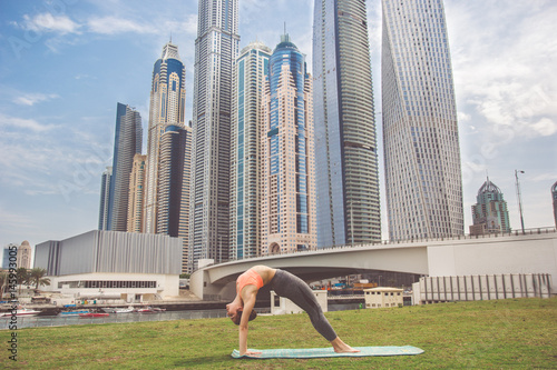 Photography Young girl doing stretching against skyscrapers