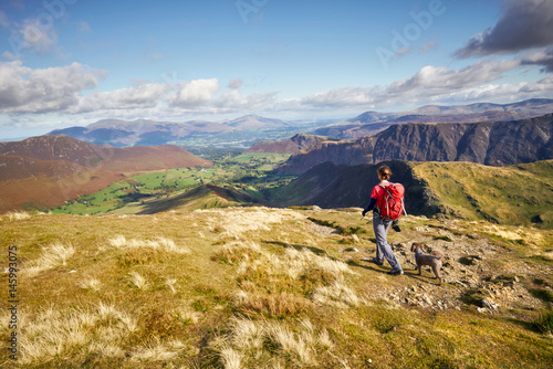 A hiker walking down towards High Snab Bank from the summit of Robinson in the Lake District, England, UK.