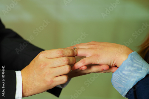 Close up shot of man putting ring on his girlfriend hand
