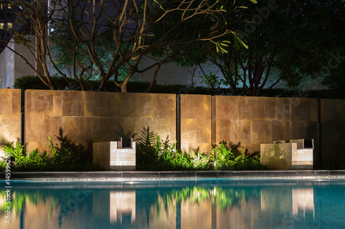 Romantic evening mood lighting casting shadows onto a romantic setting near the pool.  This luxury home has some of the best landscaped gardens and tropical flora in the world.