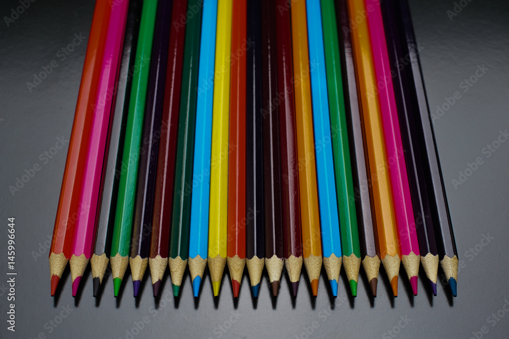 many colored pencils on a black background many colored pencils on a black background