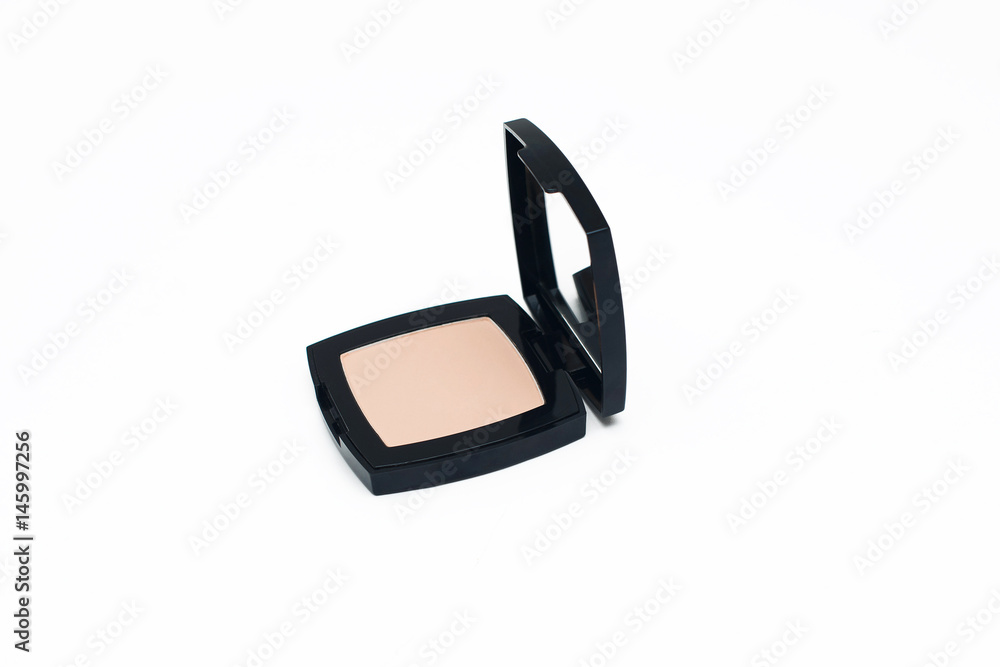 Beige cosmetic powder in a square black container with mirror on white background Beige cosmetic powder in a square black container with mirror on white background