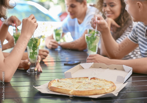Friends eating pizza in cafe