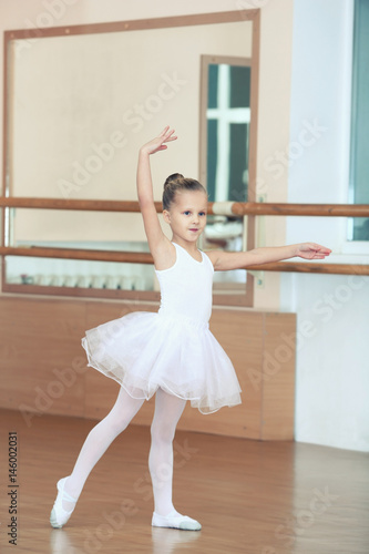 Beautiful little girl practicing ballet at class