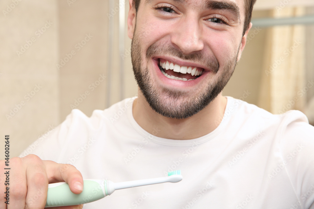 Handsome man brushing teeth in bathroom Handsome man brushing teeth in bathroom