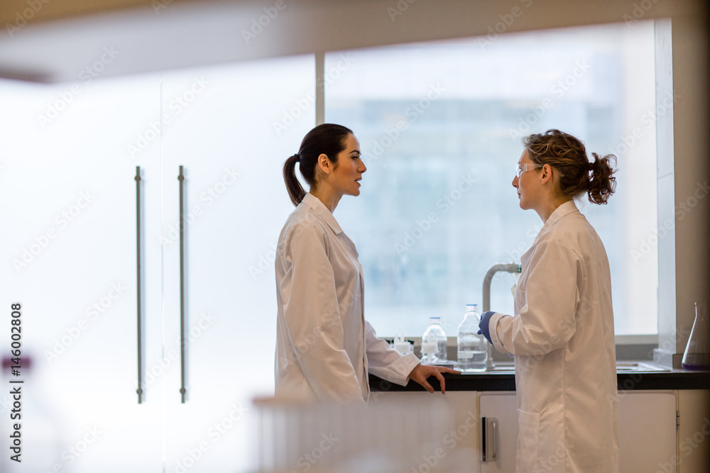 Two female scientists discussing results of experiment Two female scientists discussing results of experiment