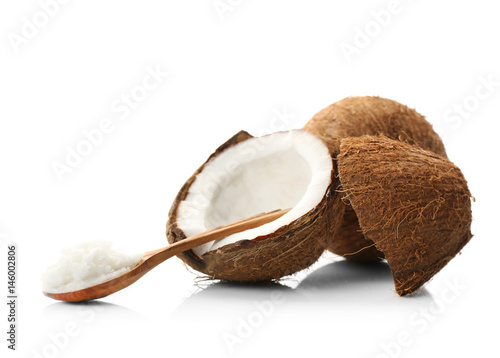 Composition with coconut butter in wooden spoon and nut on white background