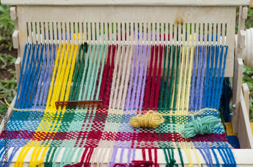 Colored threads in a wooden loom, on the market in Bashkiria