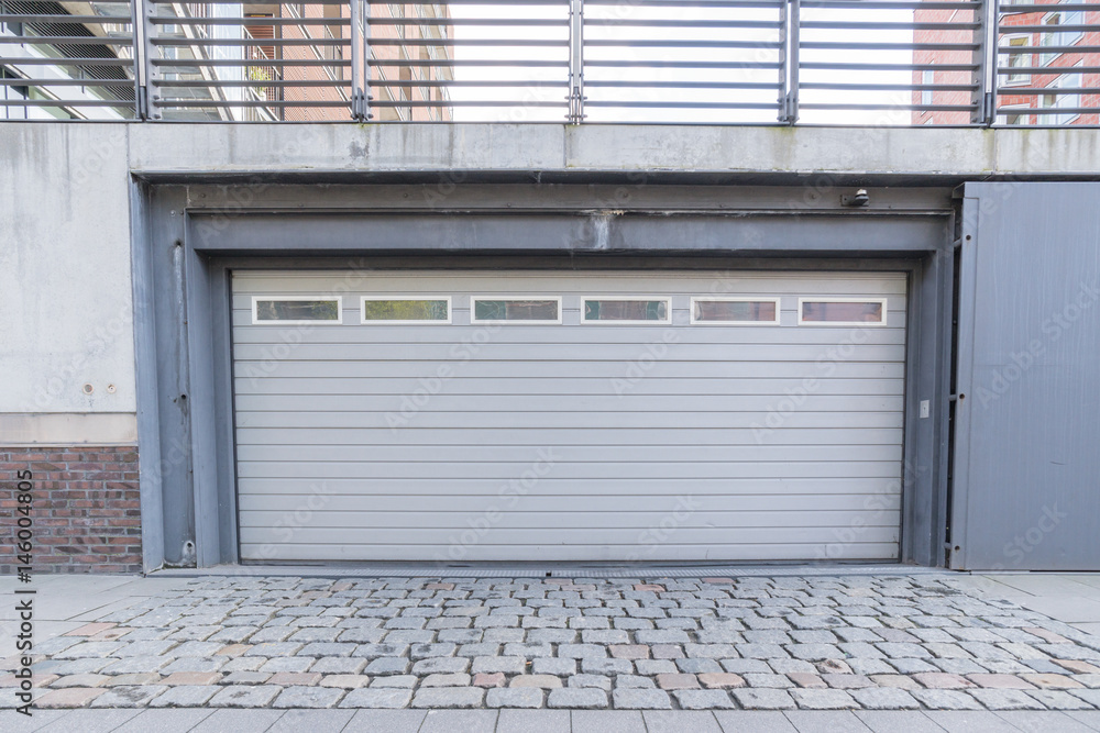 Einfahrt einer Tiefgarage mit weißem Tor Einfahrt einer Tiefgarage mit weißem Tor
