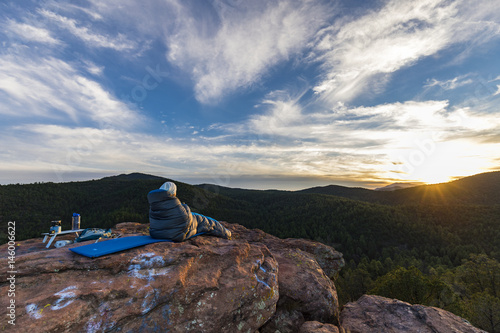 woman in a sleeping bag looking out at the mountains 