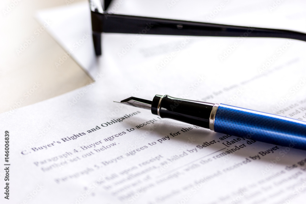 Pen and glasses lying on signed documents on office desk Pen and glasses lying on signed documents on office desk