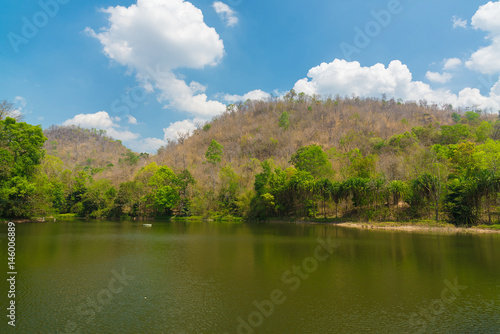 Lake near mountain and tree with sky and cloud.