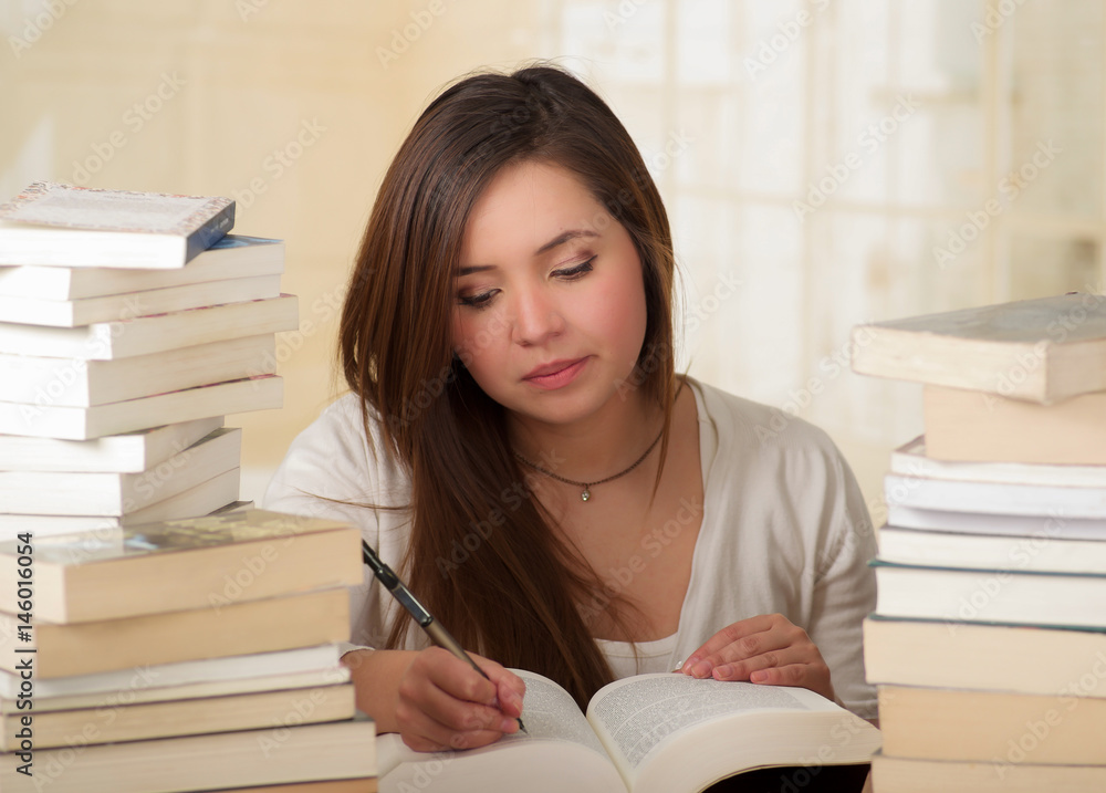 tired student girl writing and falling asleep with books in the library tired student girl writing and falling asleep with books in the library