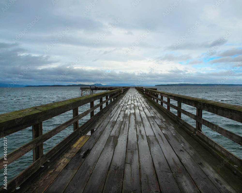 Wooden pier under stormy clouds after the rain. Sidney BC, Vancouver Island