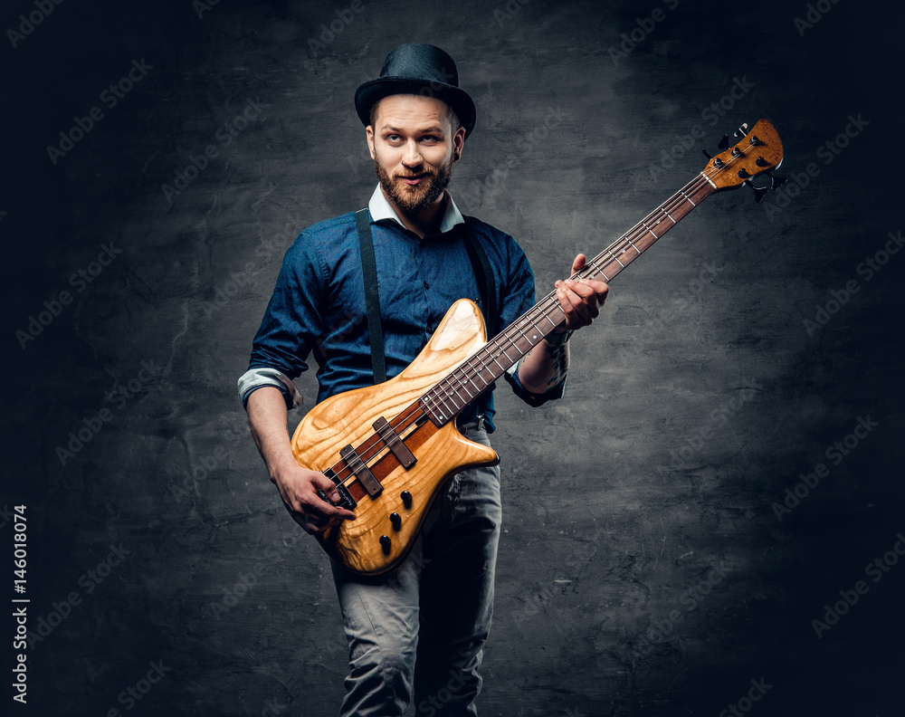 Φωτογραφία Studio portrait of the hipster bass player dressed in cylinder hat