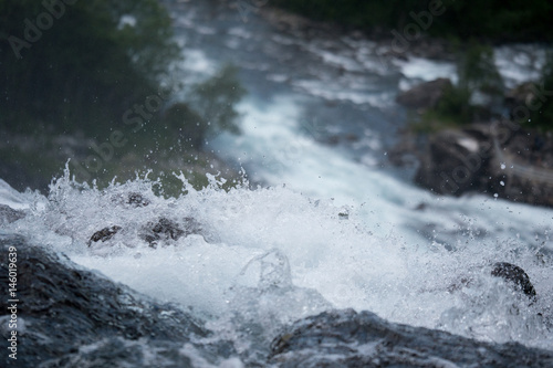Waterfall in mountains of Norway in rainy weather.